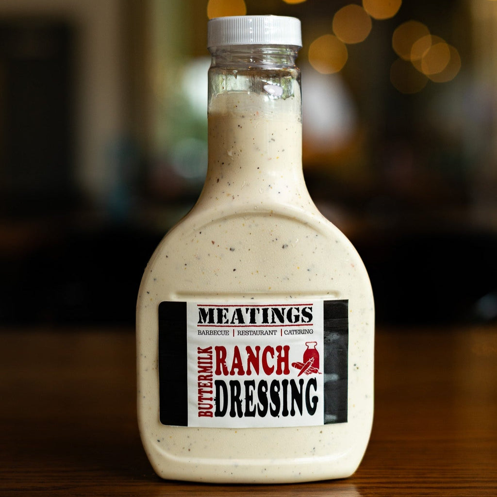 Bottle of Meatings Buttermilk Ranch Dressing on a wooden surface with a blurred background