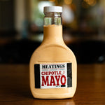 Bottle of MEATINGS Chipotle Mayo on a wooden surface with a blurred background