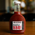 Bottle of MEATINGS Maple BBQ Sauce on a wooden surface with blurred background